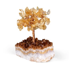 Detailaufnahme von gelbem Kristall-Geldbaum mit Kupferdraht auf einem Natursteinsockel