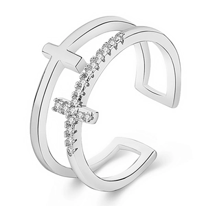 Macro detail of a double-layer silver cross ring featuring sparkling cubic zirconia stones