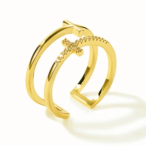 Detail of double-layer golden cross ring with pavé-set crystals and polished finish