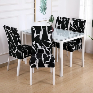 Elastic chair covers featuring modern black and white abstract patterns in a dining room
