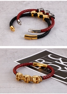 Detail of woven leather bracelets featuring skull charms and magnetic metal clasps