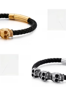 Macro detail of braided leather bracelets with gold and silver skull charms