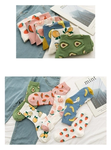 Detail shot of colorful socks featuring embroidered avocado and peach fruit patterns