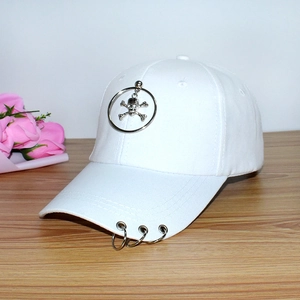Close-up of white canvas baseball cap featuring metal rings and skull pendant detail