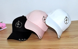 Detailed shot of baseball caps in black pink and white with metal rings and aircraft logo