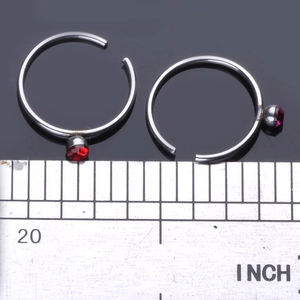 Silver C-shaped stainless steel nose rings with red rhinestones and size measurement