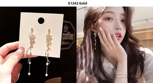 Detail of long star tassel earrings with gold plating and white pearls on Asian model