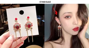 Detail of Peking Opera mask earrings with red enamel, white pearls and gold tassels