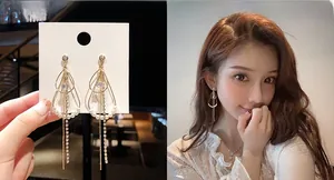Detail of gold teardrop pearl earrings with long rhinestone tassels on a model