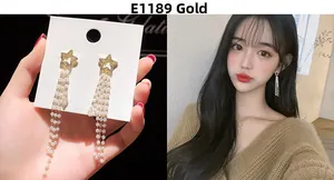 Detail of E1189 Gold star earrings featuring rhinestone studs and long pearl tassels