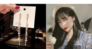 Detailed close-up and model view of golden tassel earrings with teardrop diamonds