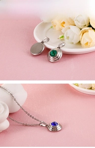 Macro detail of fine steel pendant featuring layered rings and inset round gemstones