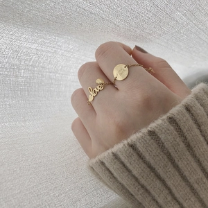 Detailed close-up of 14K gold plated titanium rings with 'love' and 'Good luck' engravings