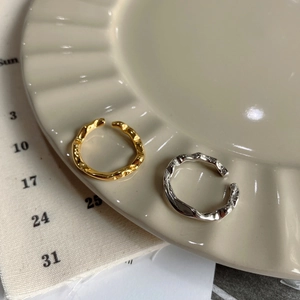 Detailed view of irregular hammered texture on gold and silver minimalist open rings