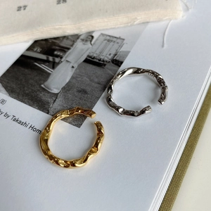 Detail shot of silver and gold wave rings showing S925 engraving on minimal inner band