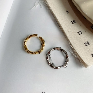 Detail of irregular textured 925 sterling silver rings in gold and silver finish