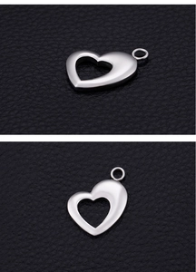 Macro shot of silver stainless steel heart pendant on textured black leather surface