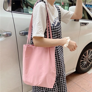 Pink washed cotton canvas tote bag with slim shoulder straps shown on a model