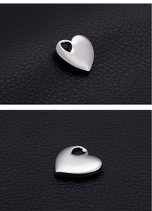 Macro detail of polished stainless steel heart pendant showing front and side profile