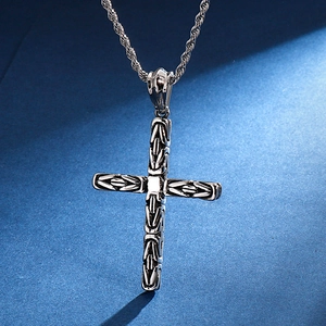 Pendentif croix vintage en acier inoxydable argenté avec chaîne torsadée sur fond bleu