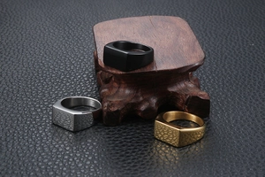 Three men's minimalist rectangular signet rings in gold, silver, and black finish