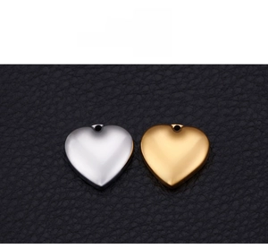 Polished gold and silver heart pendants displayed on black leather background