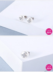 Detail of cross-shaped metal inlay on a round white pearl earring for women
