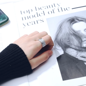 Minimalist silver wide ring with irregular textured surface worn on index finger