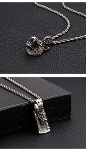 Detailed close-up of retro dragon and wolf head pendants on twisted curb chains