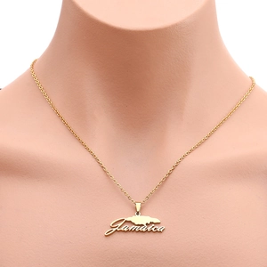 Detail shot of a golden stainless steel chain necklace featuring a Jamaica map word pendant