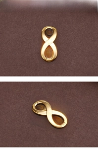 Macro detail view of a polished gold infinity symbol connector for DIY jewelry making
