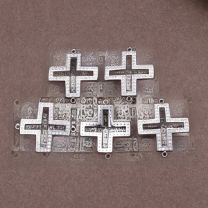 Five hollow cross pendants with inlaid diamonds for DIY jewelry making on brown texture
