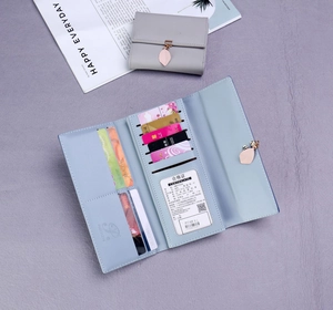 Detail of multi-card slots and leaf metal charm on long leather wallet