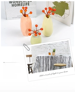 Three colorful ceramic vases with artificial red berry sprigs for home decor