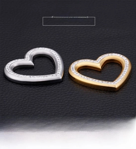 Macro shot of gold and silver heart-shaped pendants with micro-pave crystals