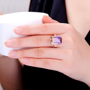 Close-up of rose gold ring with large rectangular gradient gemstone and small diamonds