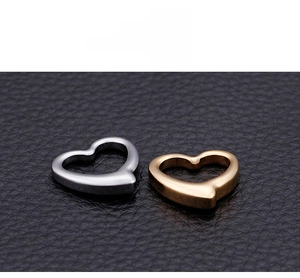Detailed view of heart-shaped hollow pendants in gold and silver stainless steel