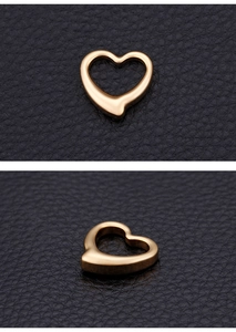 Macro view of gold heart pendant with hollow design on black leather background