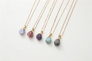 Detailed set of five natural raw crystal stone pendants on gold chains in various colors