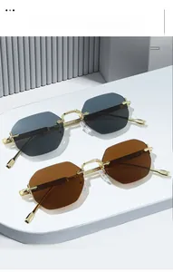 Detail of octagonal rimless sunglasses with gold metal frames and gradient lenses