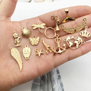 Assorted gold metal charms including wings, starfish, and crowns for DIY jewelry making
