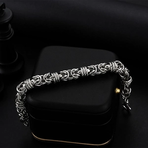 Men's silver titanium steel woven bracelet displayed on a premium black gift box