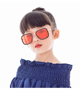 Detailed close-up of fashion children's sunglasses with thick black frames and orange lenses