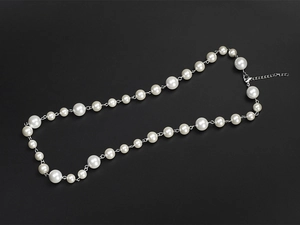 Detailed shot of white pearl necklace with silver chain link and lobster clasp fastener