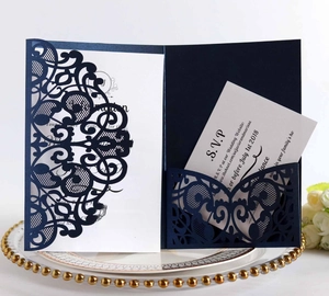 Detailed laser-cut navy blue wedding invitation suite with intricate lace patterns