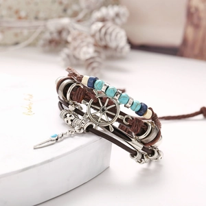 Detail of vintage multilayer leather bracelet with turquoise beads and anchor charm