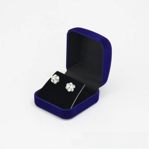 Close-up of sparkling spherical stud earrings inside a premium blue velvet jewelry gift box