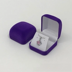 Macro shot of purple velvet jewelry gift boxes showing closed and open storage for necklaces