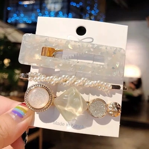 Detailed view of 3-piece hair clip set with acetate, pearls, and gold metal accents