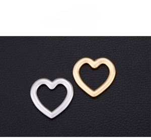 Close-up of heart-shaped stainless steel charms in polished gold and silver finishes